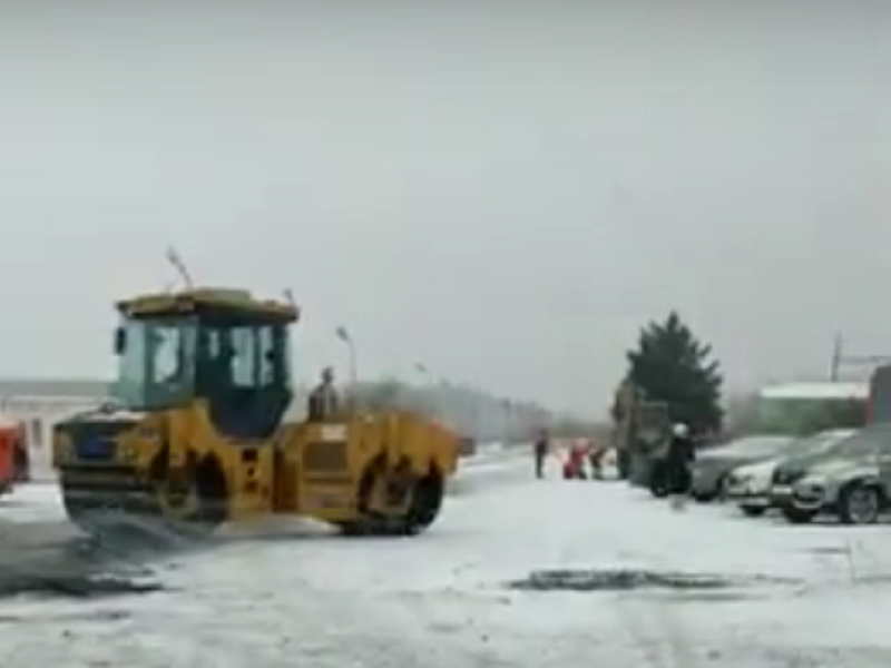 В Таганроге новую дорогу к школе на Галицкого асфальтируют во время снегопада